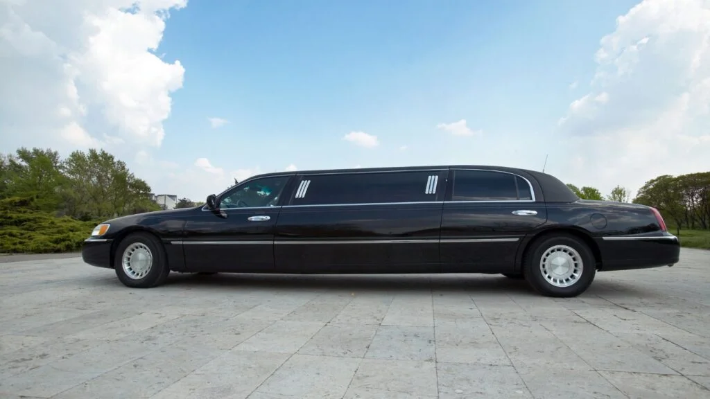 A black limo parked on the side of a road.