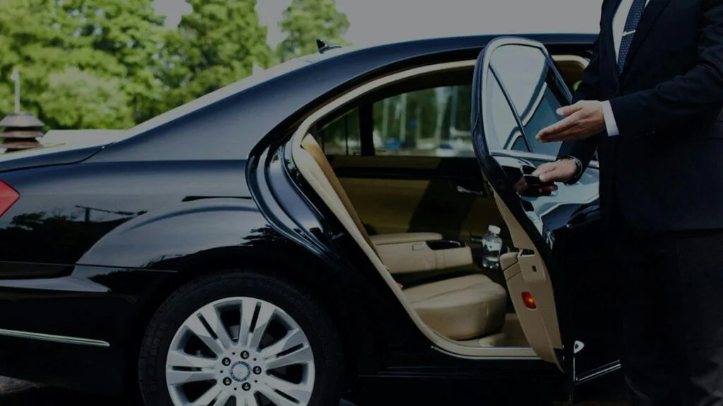 A person sitting in the drivers seat of a car.