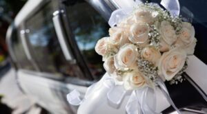 A bouquet of flowers is sitting on the hood of a car.