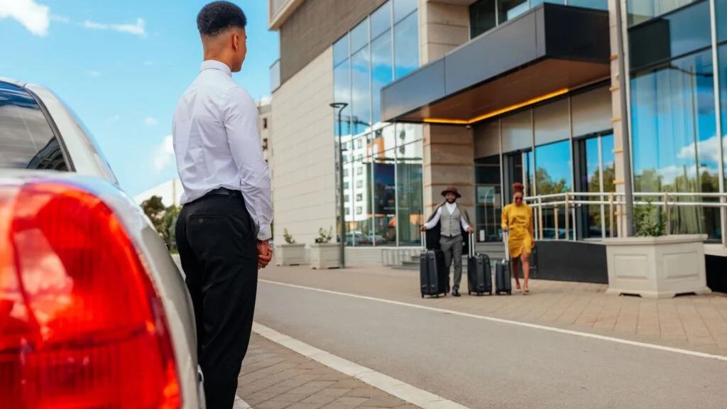 A man standing next to a car on the street.