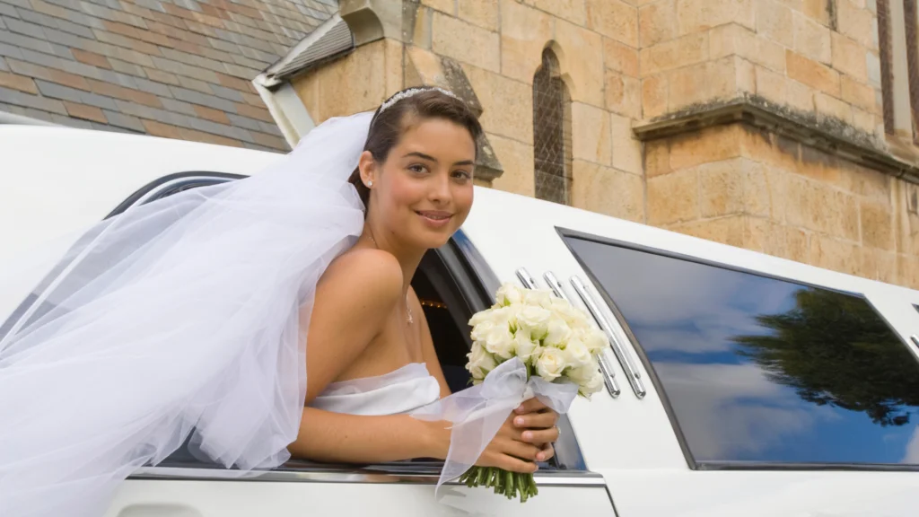 A bride sitting in the back of her limo