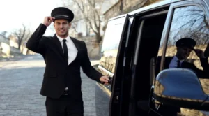 A man in black suit and hat standing next to a car.