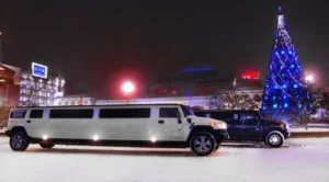 A white limo is parked in the snow.