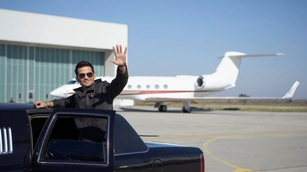 A man waving from the back of his truck.