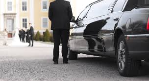 A man standing next to a parked car.