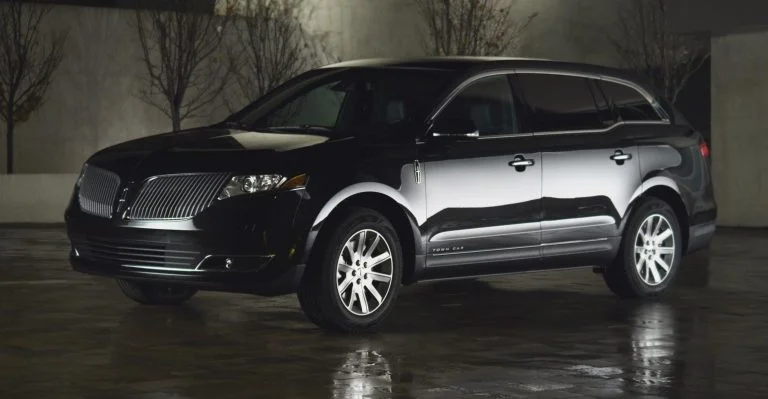 A black and silver car parked in the rain