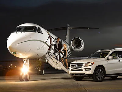 A man and woman getting off of an airplane.