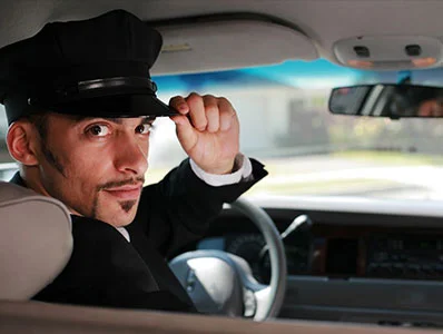 A man in a hat sitting inside of a car.