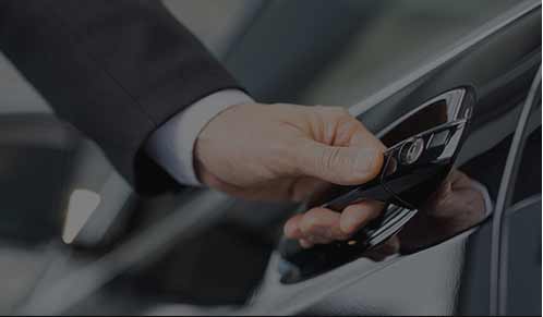 A person holding onto the door of their car