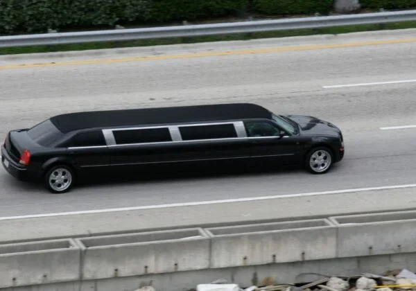 A black limo driving down the street