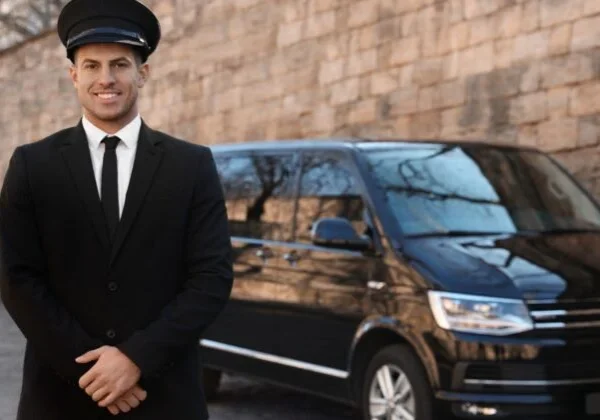 A man in a suit and tie standing next to a van.