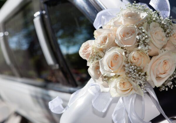 A bouquet of flowers is sitting on the hood of a car.