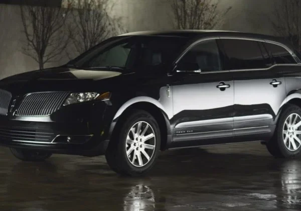 A black and silver car parked in the rain