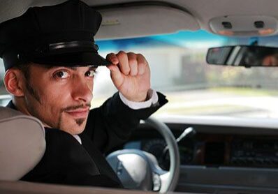 A man in a car wearing a hat