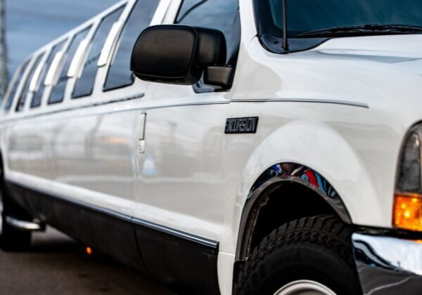 A white limo is parked in the parking lot.